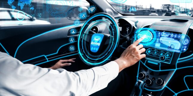 Fahrer in automatisiertem Fahrzeug blickt auf digitale Steuerelemente.