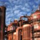 Alte energieintensive Infrastruktur mit Rostigen Rohren und Schornsteinen