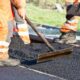 Bauarbeiter verteilen Asphalt