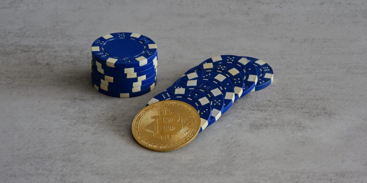 Ein Bitcoin und blaue Chips aus dem Casino