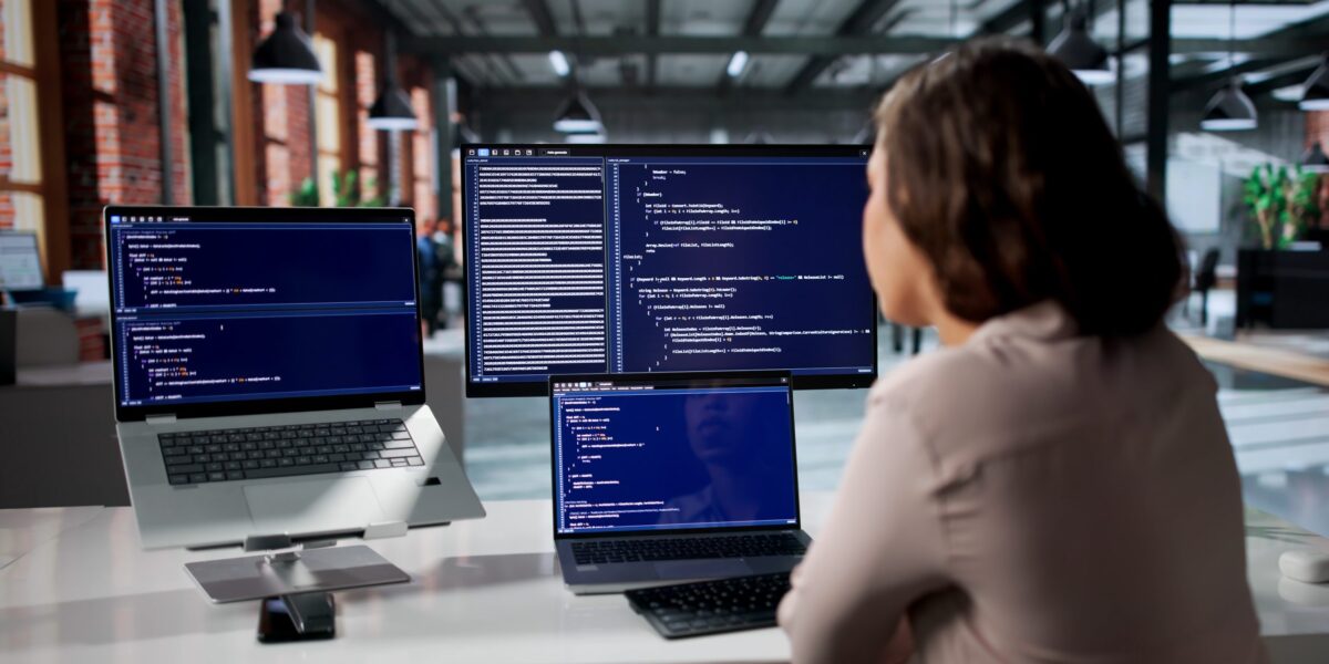 Junge Softwareentwicklerin konzentriert sich am Schreibtisch auf die Programmierung sicherer Webanwendungen.