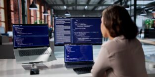 Junge Softwareentwicklerin konzentriert sich am Schreibtisch auf die Programmierung sicherer Webanwendungen.