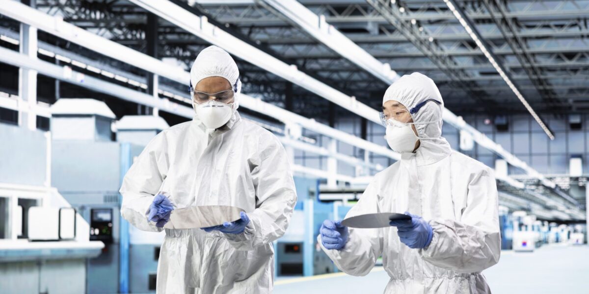 Ingenieurteam transportiert Silikonwafer innerhalb eines Reinraums.