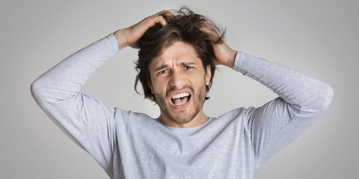 Mann rauft sich die Haare