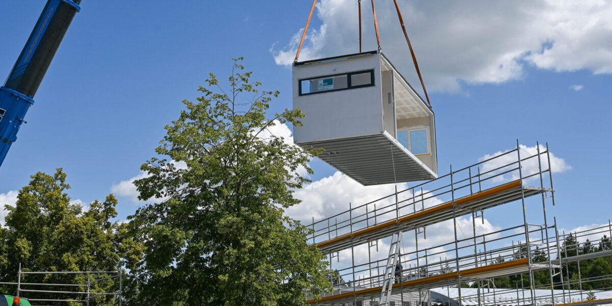 Ein vorgefertigtes Raummodul wird per Kran an seinen Platz gehoben