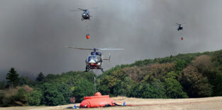 Helikopter fliegen an, um Wasser in Löschwasser-Außenlastbehältern zum Einsatz beim Waldbrand im Hürtgenwald aufzunehmen