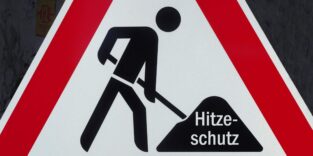 Baustellenverkehrsschild, hineinmontiert in den symbolischen Erdhaufen ist der Schriftzug "Hitzeschutz"
