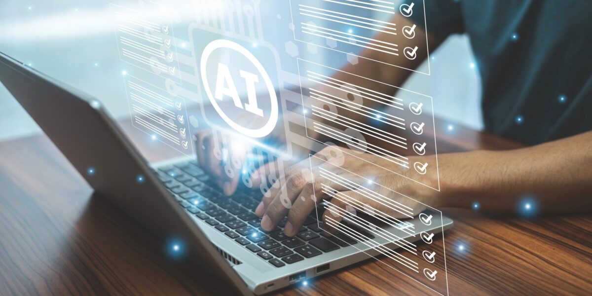 Mann tippt auf Laptop, darüber ein AI-Logo