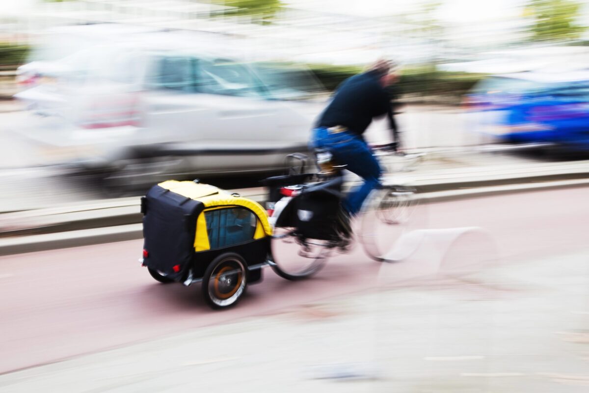 Mann fährt Fahrrad mit Anhänger