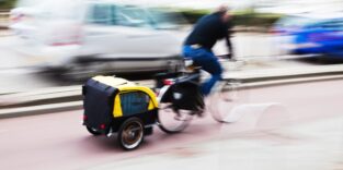 Mann fährt Fahrrad mit Anhänger