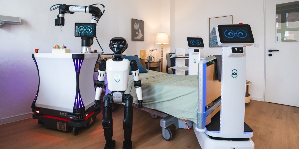 Man sieht verschiedene Roboter, humanoid und auf Plattformen in einem Pflegezimmer.