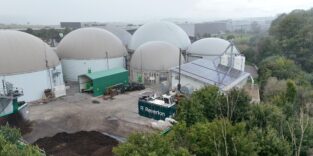 Luftaufnahme einer Biogasanlage mit mehreren grauen Fermenterkuppeln