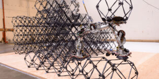 Ein SOLL-E-Roboter bewegt sich auf einer aus modularen Voxeln aufgebauten Gitterstruktur