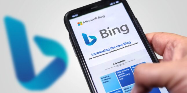 Person tippt auf dem Smartphone etwas in die Suchmaschine Bing von Microsoft ein