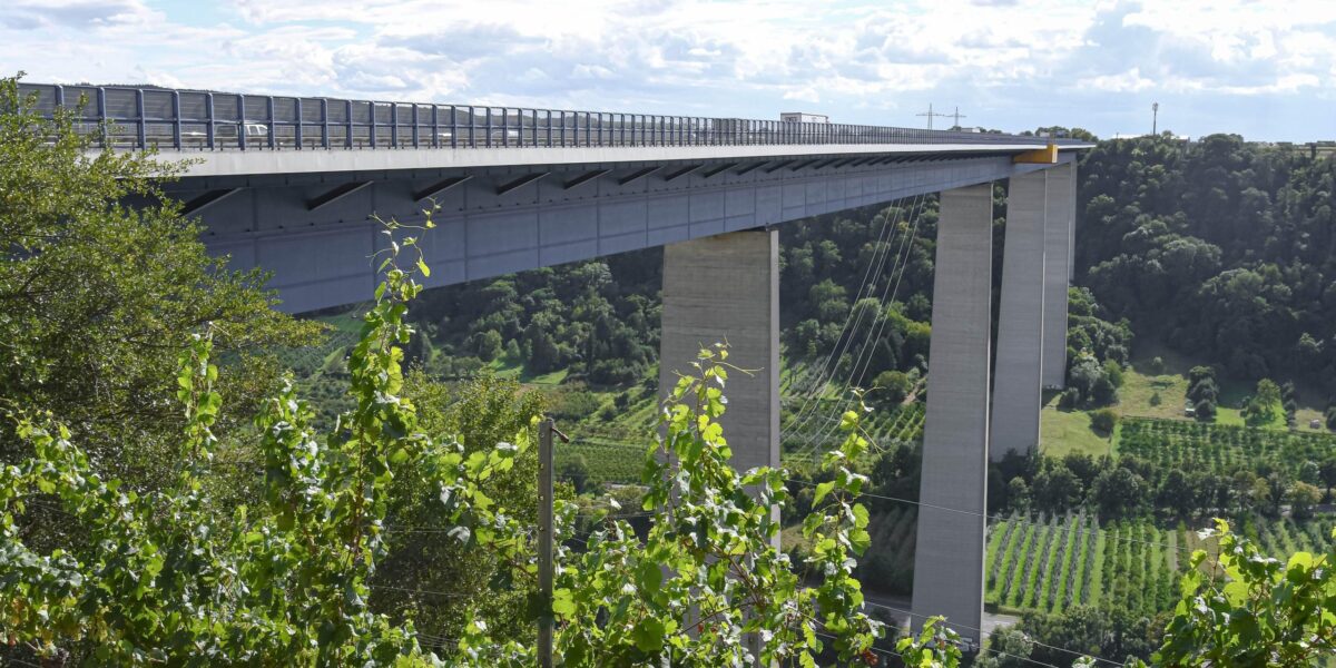 Moseltalbrücke Winningen der A61 über dem Moseltal mit hohen Betonpfeilern und Weinbergen im Vordergrund.