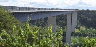 Moseltalbrücke Winningen der A61 über dem Moseltal mit hohen Betonpfeilern und Weinbergen im Vordergrund.