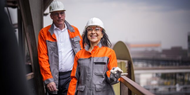 Bundeswirtschaftsministerin Katherina Reiche (CDU, im Bild rechts) mit schutzhelm auf einem Turm