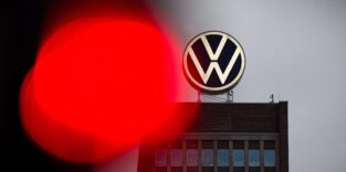 Eine Ampel leuchtet am Morgen neben dem VW-Markenhochhaus rot.