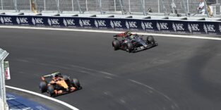 Zwei Formel-1-Rennwagen fahren durch eine Steilkurve.