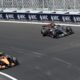 Zwei Formel-1-Rennwagen fahren durch eine Steilkurve.