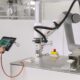 Frau programmiert Roboter via Tablet.