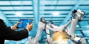 Zwei Arme halten ein Ipad, das einen Industrieroboter scannt