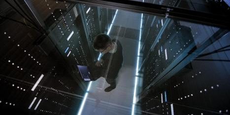 Mann mit Laptop im Serverraum