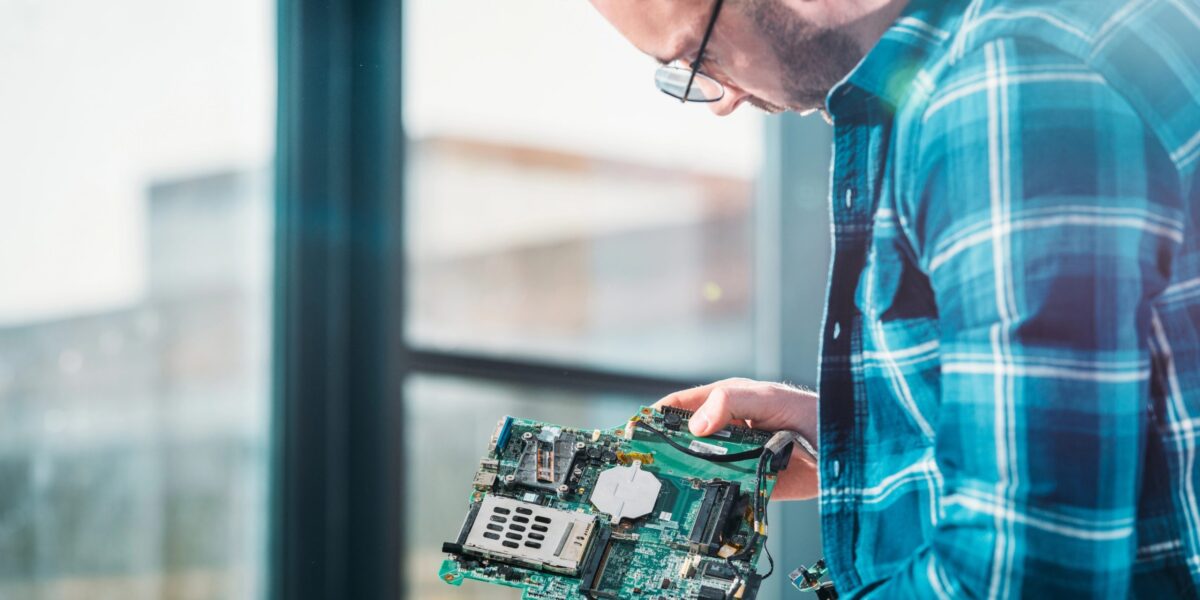 Bild eines Hardwareentwicklers bei der Arbeit an einer Leiterplatte