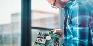 Bild eines Hardwareentwicklers bei der Arbeit an einer Leiterplatte