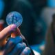 Mann hält Bitcoin-Münze in der Hand
