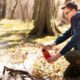 Mann löscht Feuerstelle im Wald mit Feuerlöscher