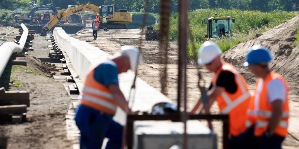 Mitarbeiter der Ontras Gastransport GmbH arbeiten bei der Erneuerung der Ferngasleitung Lauchhammer-Strehla an einem Rohrstrang zur Gewässerquerung, auch Düker genannt, am Ufer der Elbe. Die Erneuerung des rund 35 Kilometer lange Abschnitts soll eine effiziente Energieversorgung für die Regionen zwischen Lauchhammer und Riesa sicherstellen. (Luftaufnahme mit Drohne)