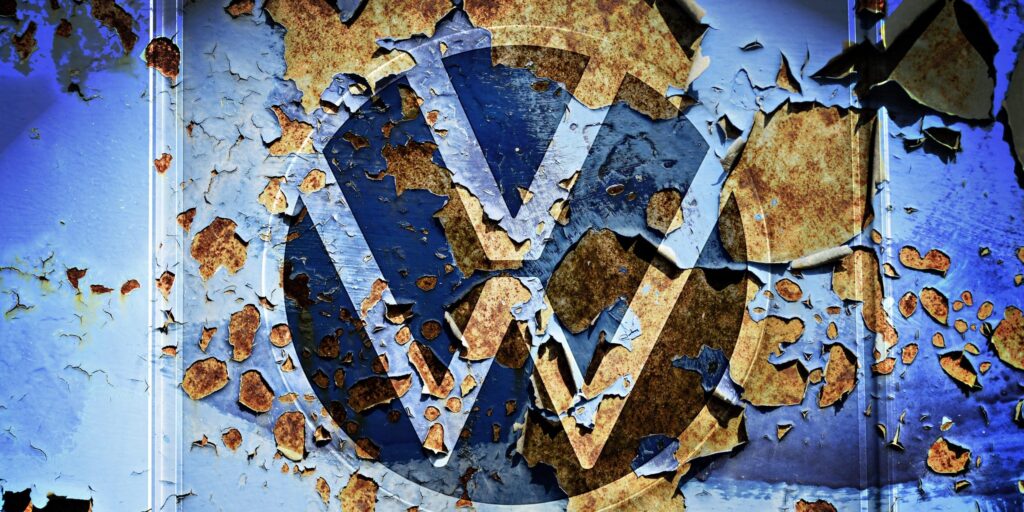 VW-Zeichen eines Autohändlers auf abblätternder Farbe an einer Wand, Symbolfoto VW-Krise, Fotomontage Foto picture alliance / CHROMORANGE | Christian Ohde