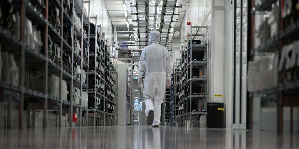 Eine Mitarbeiterin läuft durch den Reinraum einer Halbleiterfertigung von Nexperia