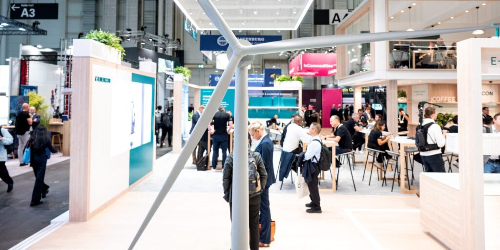 Messehalle, Ausstellerstand mit Windradmodell im Vordergrund.