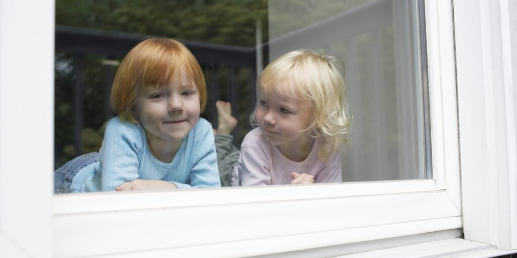 Zwei Mädchen blicken aus dem Fenster