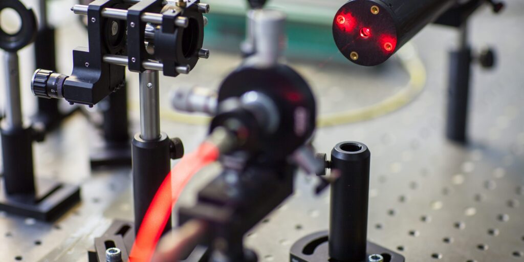 Quantum optics lab installations with laser, irises, appertures - laser reflect on optic table un quantum laboratory