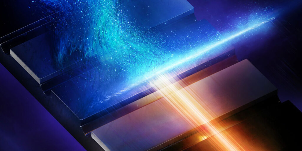 Illustration eines stark fokussierten Röntgenpulses mit blauem und orangefarbenem Licht auf einer metallischen Struktur.