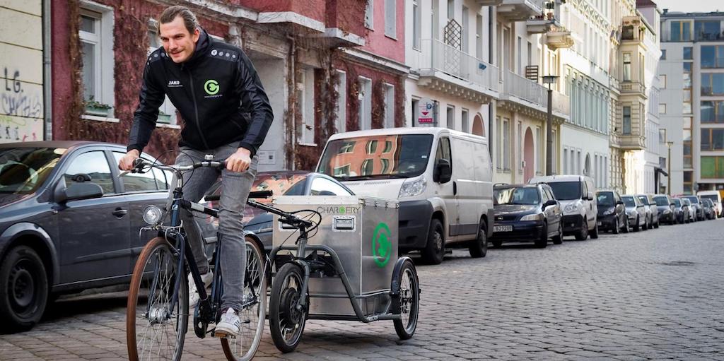 Fahrradkurier lädt Elektroautos auf