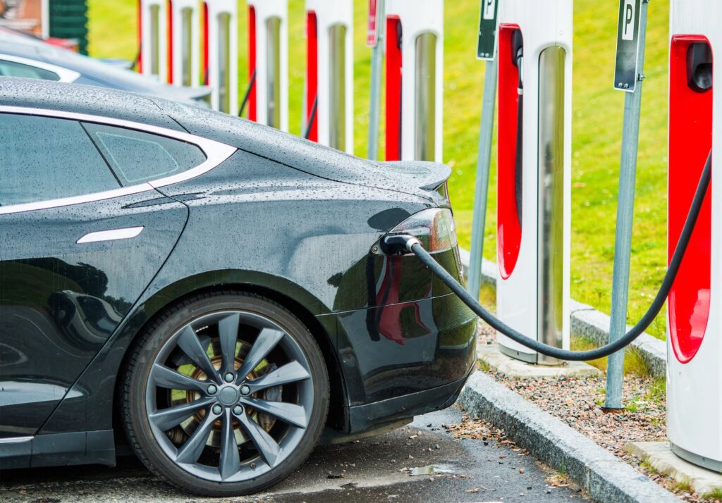 E-Auto steht an einer Ladesäule, neben der noch weitere stehen.