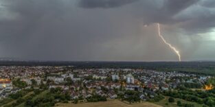 Gewitter mit Blitz über einer Stadt.
