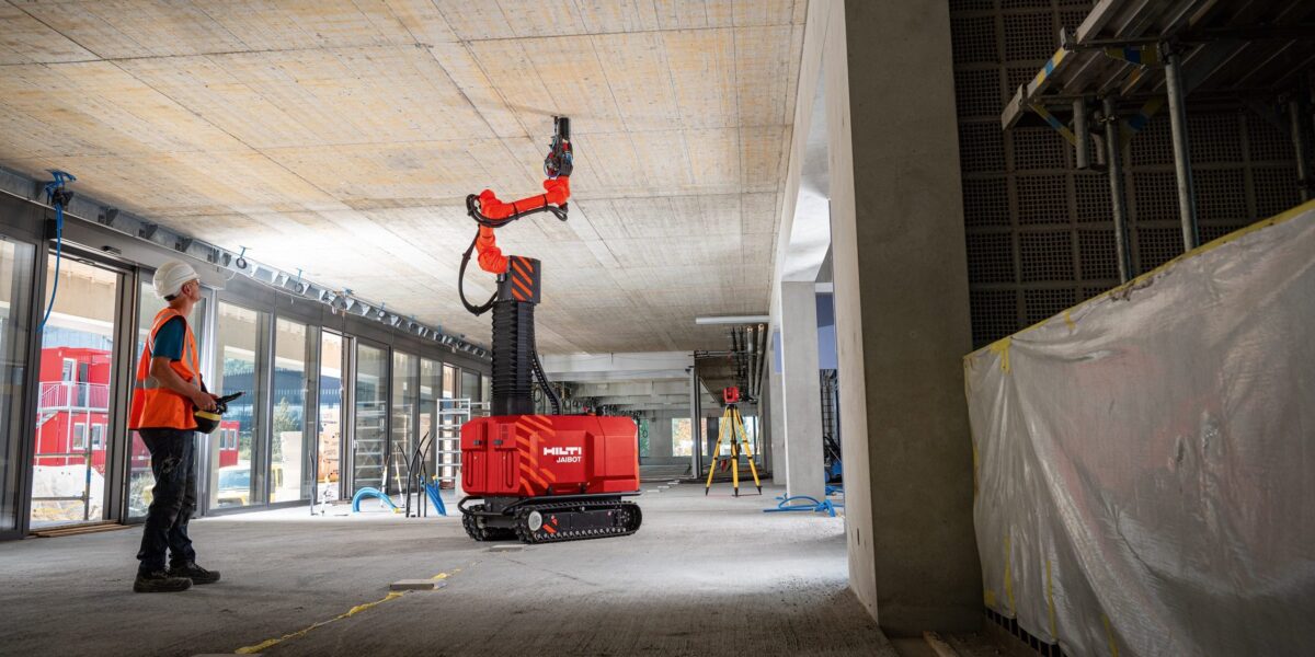 Der Hilti Jaibot führt Deckenbohrungen anhand digitaler Planungsdaten aus. Ein Mitarbeiter bedient den Roboter, der die belastende Überkopfarbeit übernimmt. Foto: Hilti Aktiengesellschaft