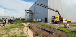 Kran verlegt Rohrleitung