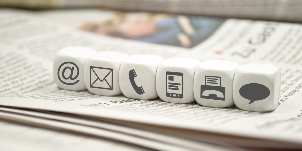 Schriftform, dargestellt durch Würfel mit @-, Brief-, Telefon- und Sprechblasen-Zeichen
