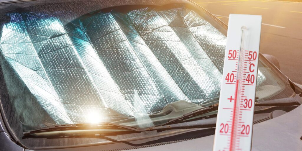 Thermometer zeigt über 40 Grad an, im Hintergrund eine Windschutzscheibe mit Abdeckung