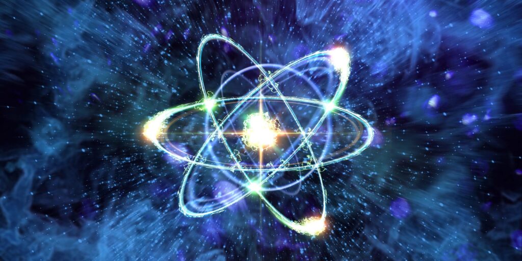 Künstlerische Darstellung eines leuchtenden Atoms mit mehreren sich kreuzenden Elektronenbahnen vor blau-violettem Hintergrund.