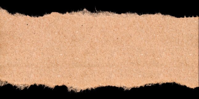 Brauner Papierstreifen mit ausgefransten Risskanten vor schwarzem Hintergrund